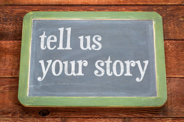 istock Tell us your story - text on slate blackboard 920681230