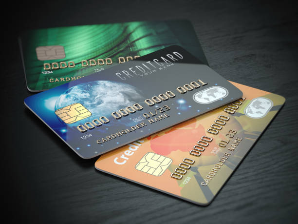 istock Three colored credit cards isolated on black wooden desk background, 920681498