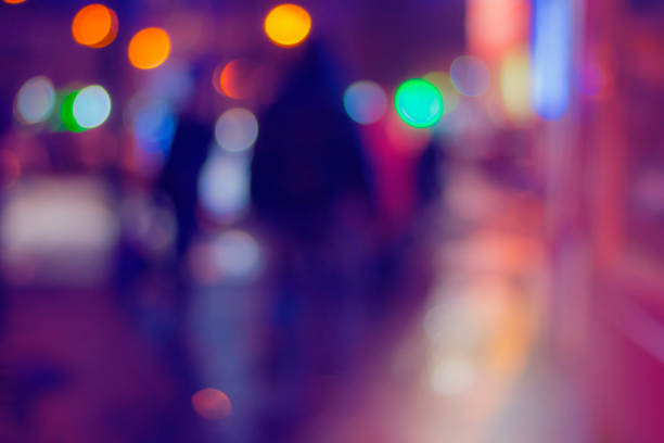 Passers-by on a city street at night. Blurred background.