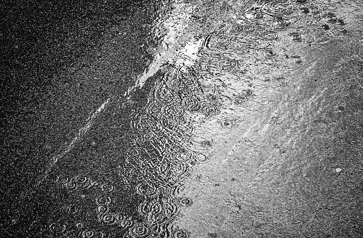 Drops of rain falling on the ground in street, winter and autumn
