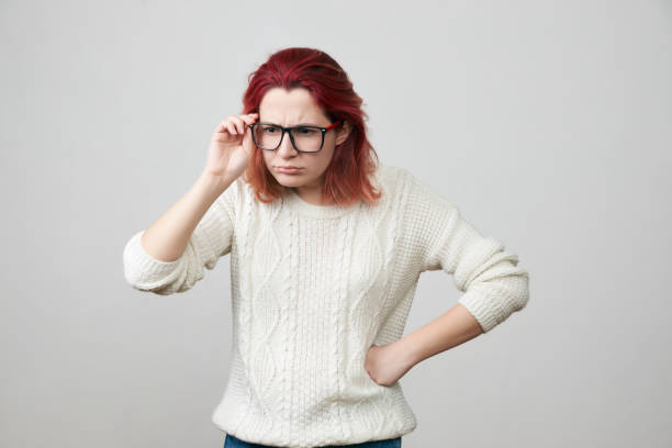 mujer en gafas con expresión confundida y triste - mano sobre cadera fotografías e imágenes de stock