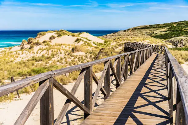 Wooden footbridge over sand dunes on Majorca island at the bay of Cala Mesquida Spain