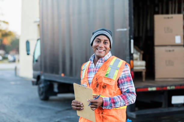 uomo afro-americano al lavoro, con camion delle consegne - delivery van truck delivering moving van foto e immagini stock