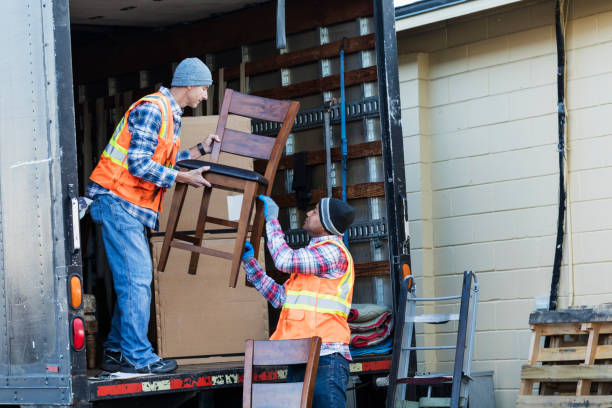 Two workers with a truck, moving furniture Two multi-ethnic mature workers in their 40s at the back of a truck, loading or unloading furniture. The men are wearing plaid shirts, reflective vests and jeans. They are moving merchandise for a furniture store. mover delivery person box hand truck stock pictures, royalty-free photos & images