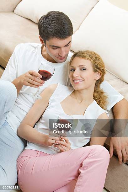 Jovem Casal Celebrando Com Vinho Tinto Em Casa - Fotografias de stock e mais imagens de Adulto - Adulto, Amizade, Amor