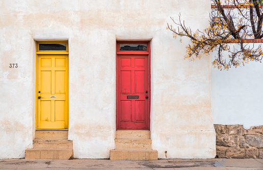 Red and yellow door on an old grungy adobe style Southwestern building in Tucson