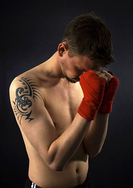 portrait of young karatist with tattoo and bandage stock photo