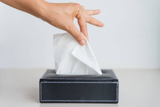 istock Woman hand picking white tissue paper from tissue box. 920717650