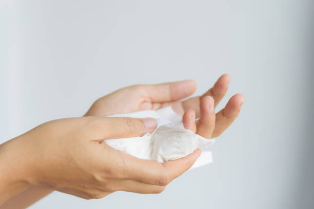Woman cleaning her hands by using white tissue paper.  isolated on a white background.