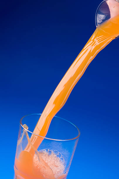 istock Pouring fresh orange juice over blue 92072266