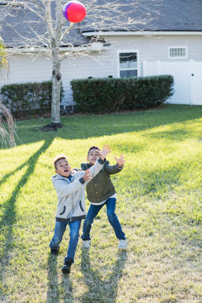 istock Two boys playing football in back yard 920736070