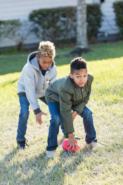 istock Two boys playing football in back yard 920738320