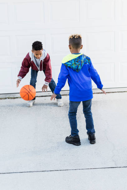 istock Two boys playing basketball on driveway 920738812