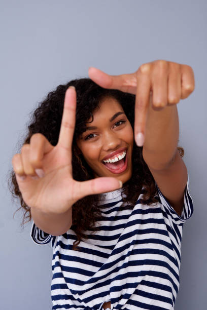 istock happy young black woman smiling and making frame with hands 920743370