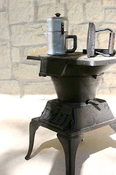 istock Old aluminum coffee pot  and iron atop mini stove. 92076639