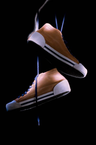 Pair of sneakers hanging from a high-voltage power line, symbolizing urban mystery, youth culture, and street scene atmosphere.