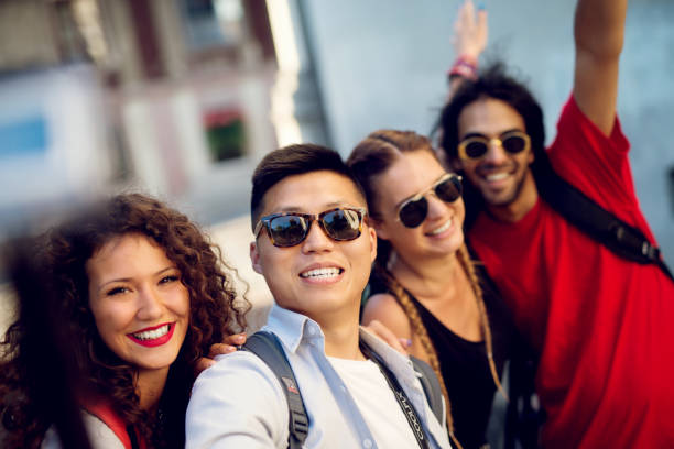istock Multiracial couples exploring a city, happy tourists discovering new locations. Making selfie. 920782302