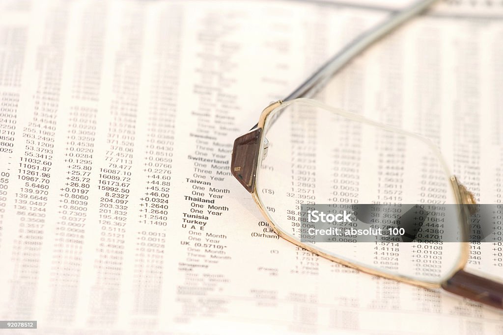 Exchange rates Eyeglasses on top of a financial newspaper with currency exchange rates Analyzing Stock Photo