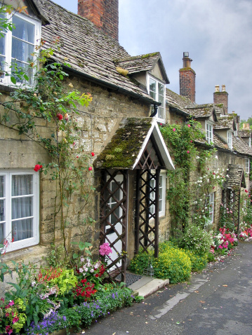 Descending gently, a row of ancient glowing stone cottages in the cotswolds are bedecked with climbing roses and moss covered slate roofs.  Gardens in front of the cottages spill onto the sidewalk- harmony abounds!