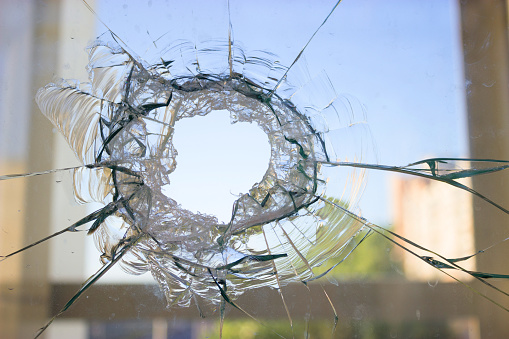 broken glass window reflecting blue sky. close up