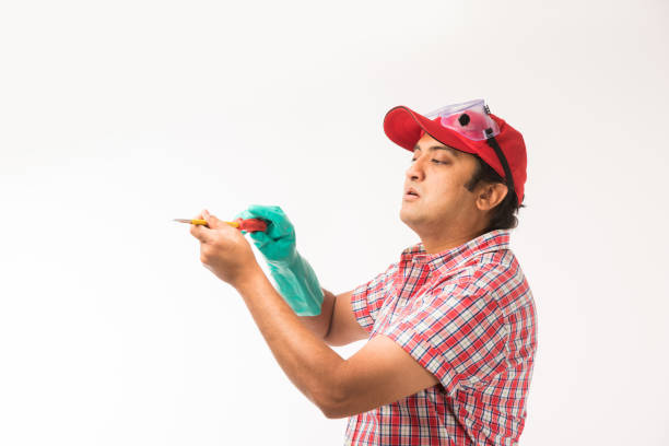 Indian electrician engineer in action with wire cutter, standing isolated over white background