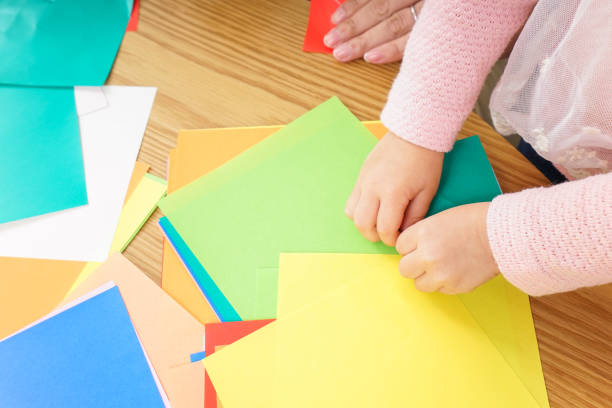 istock Child folding origami paper 920820828