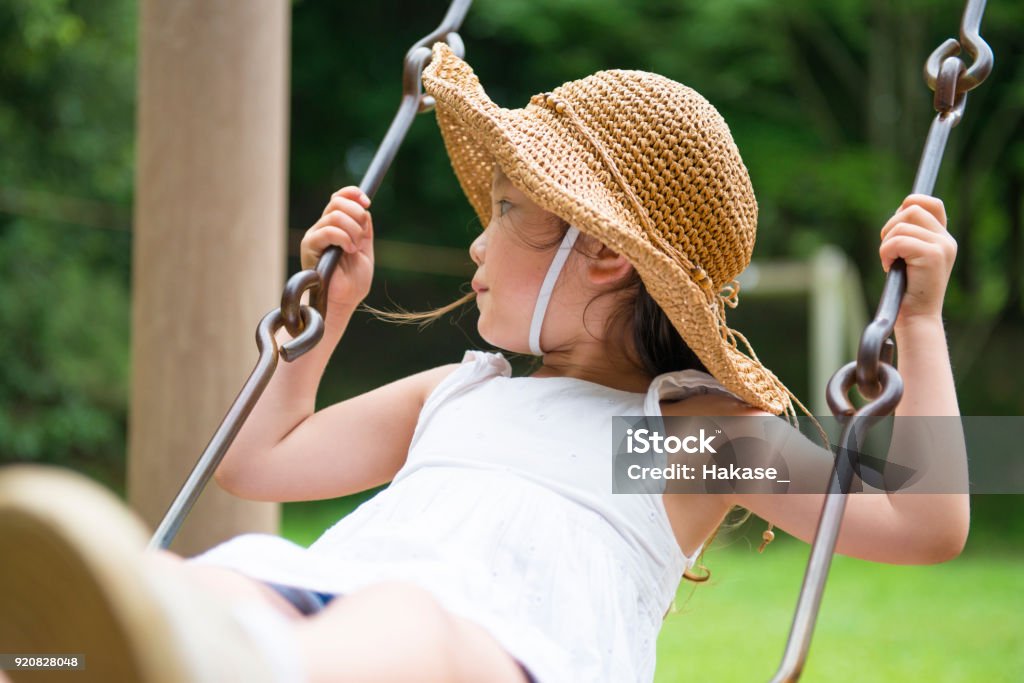 Little girl playing with a swing Public Park Stock Photo