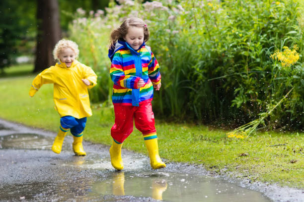 istock Kids play in rain and puddle in autumn 920828330