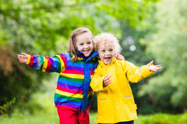 istock Kids play in rain and puddle in autumn 920830834