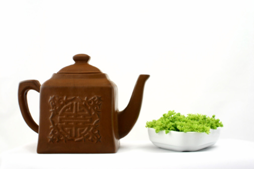 Chinese deep brown teapot isolated on white background; studio shot.