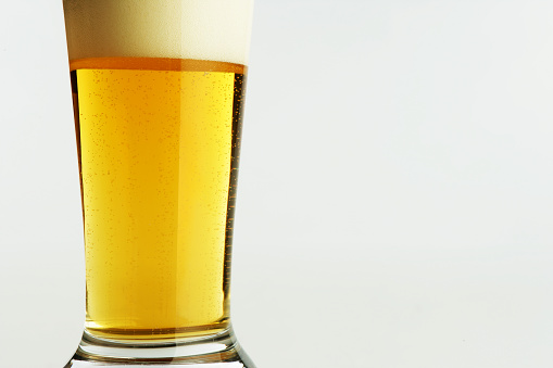 Beer glass with overflowing foam