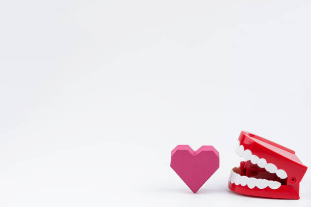 istock Red Plastic Wind Up Chattering Teeth biting paper box red heart shape at Valentine's Day.Concept Valentine's Day, Day of love. 920865650