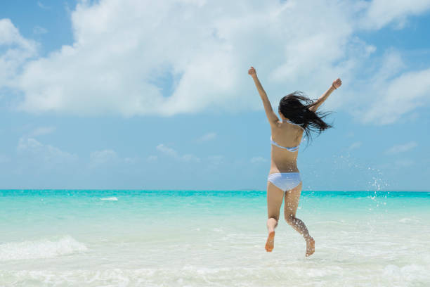istock Woman to jump at the beach 920870580