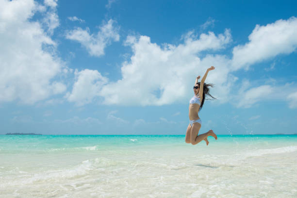 istock Woman to jump at the beach 920870650