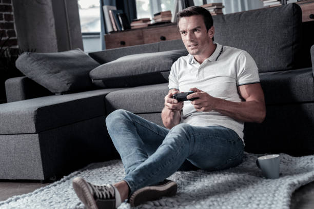 istock Concentrated millennial guy playing video games 920877780