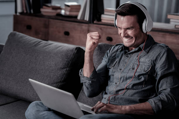 istock Satisfied man celebrating success while working on laptop 920882574
