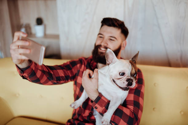 istock Young bearded man taking selfie with his cute dog 920903030