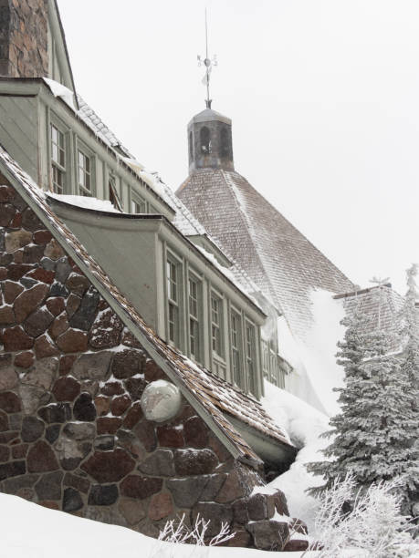 Timberline Lodge, Oregon, USA - February 15, 2018: Looking at the side of Timberline Lodge toward the center of building. The grey sky with very light snow makes for a natural low light, snowy looking color image. The unique look and history of this old building makes it a very popular destination. The Lodge is a National Historic Landmark. This is on Mt Hood located in Northwest Oregon.