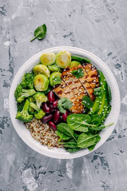 istock Healthy buddha bowl lunch with grilled chicken, quinoa, spinach, avocado, brussels sprouts, broccoli, red beans with sesame seeds 920931406