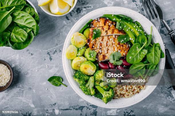 Healthy Buddha Bowl Lunch With Grilled Chicken Quinoa Spinach Avocado Brussels Sprouts Broccoli Red Beans With Sesame Seeds Stock Photo - Download Image Now