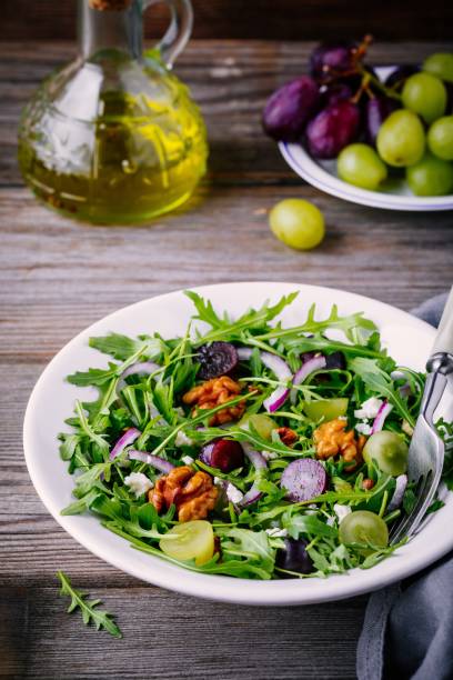 istock green salad bowl with arugula, walnuts, goat cheese, red onion and grapes 920932420
