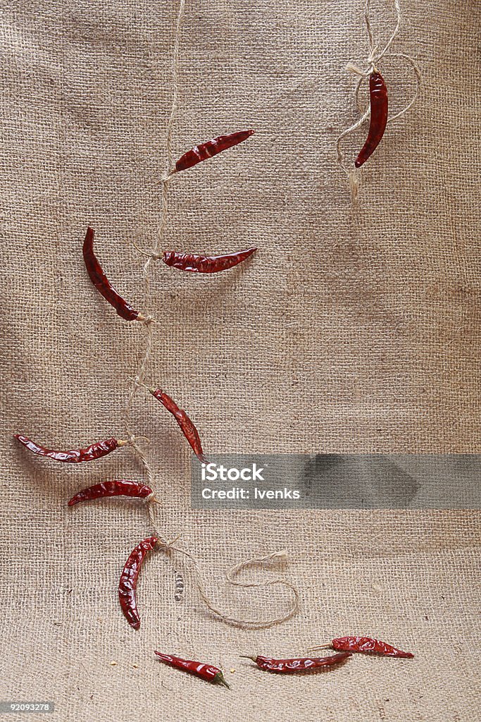 Naturaleza muerta con red chillies atada por cuerda en el hessian - Foto de stock de Abstracto libre de derechos