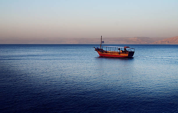 Boat on the Sea of Galilee Boat in sunset, Sea of Galilee near Capernaum, Israel. Golan Heights can be seen in the background. galilee photos stock pictures, royalty-free photos & images