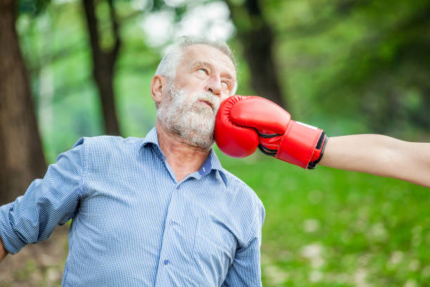 幸せな面白いシニア カップル ボクサー男と公園で赤い手袋の女 - knockout ストックフォトと画像