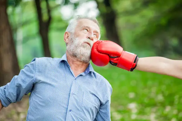 Photo of Happy funny senior couple boxer man and woman with red gloves in park