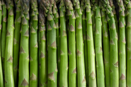 Asparagus spears bunch on wood table, close-up, no people