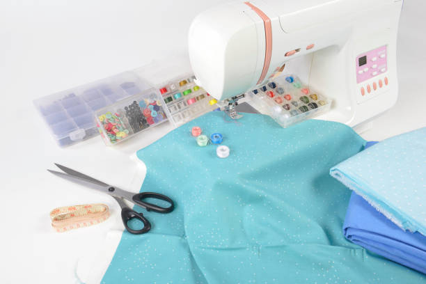 istock Sewing machine and colorful thread rolls, scissors, fabric and accessories for sewing on white background, Sewing and needlework concept. (Selective Focus) 920947836