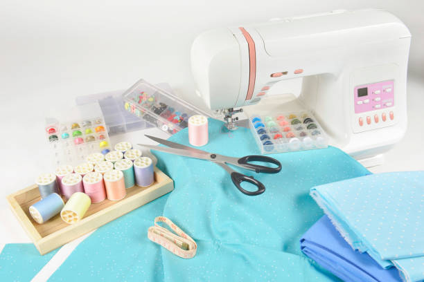 istock Sewing machine and colorful thread rolls, scissors, fabric and accessories for sewing on white background, Sewing and needlework concept. (Selective Focus) 920948118