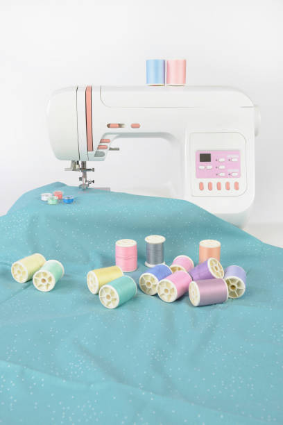 istock Sewing machine and colorful thread rolls, scissors, fabric and accessories for sewing on white background, Sewing and needlework concept. (Selective Focus) 920949036