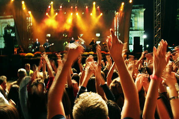 istock Crowd holding hands up against concert stage 92095535